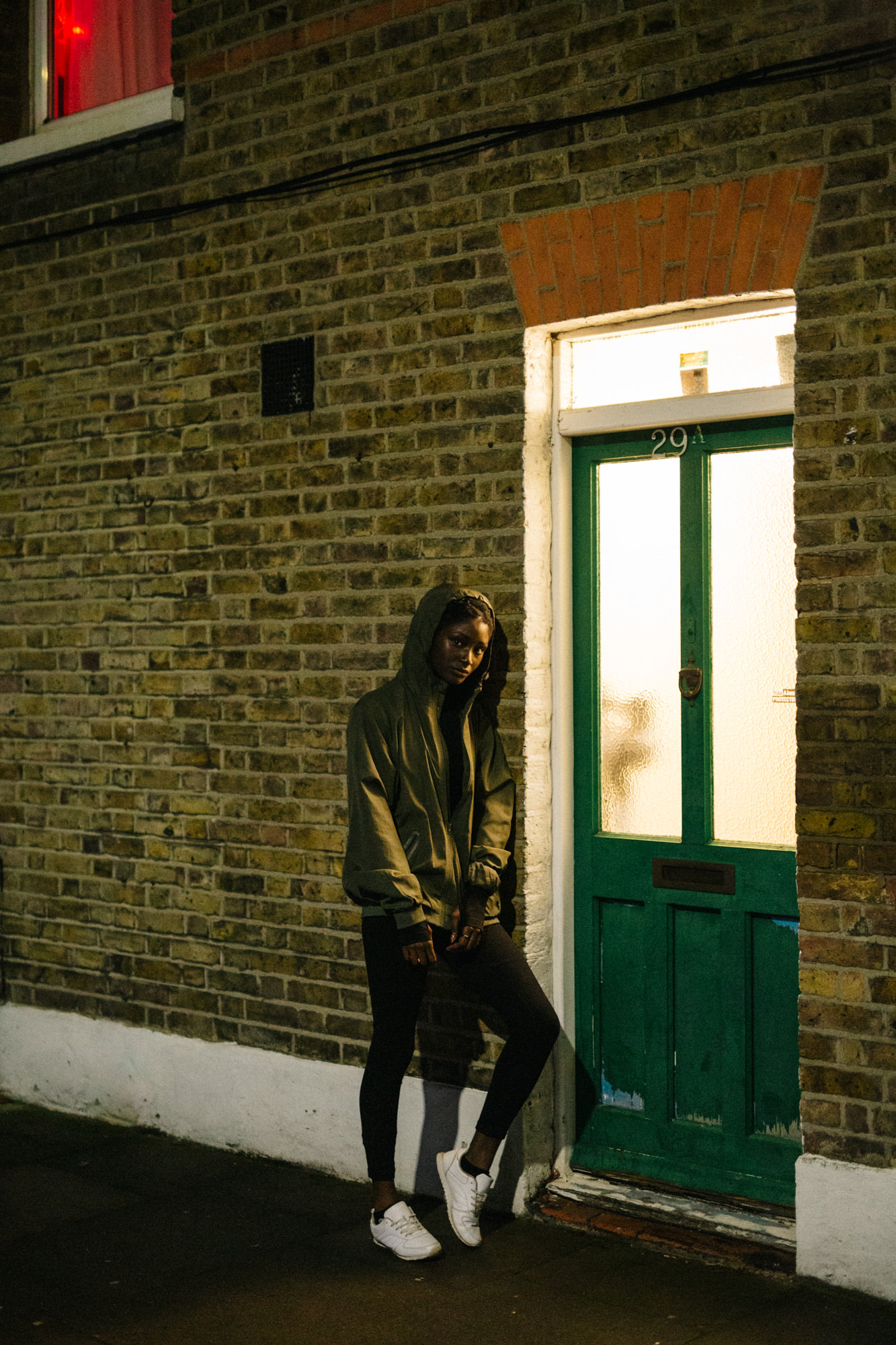 Woman leaning at wall at night