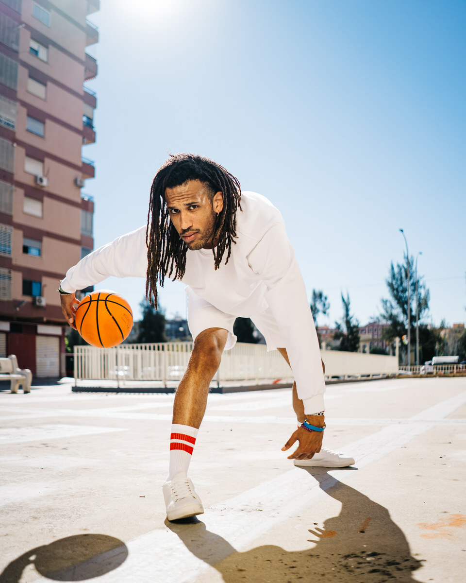 Sportsman playing basketball on street court