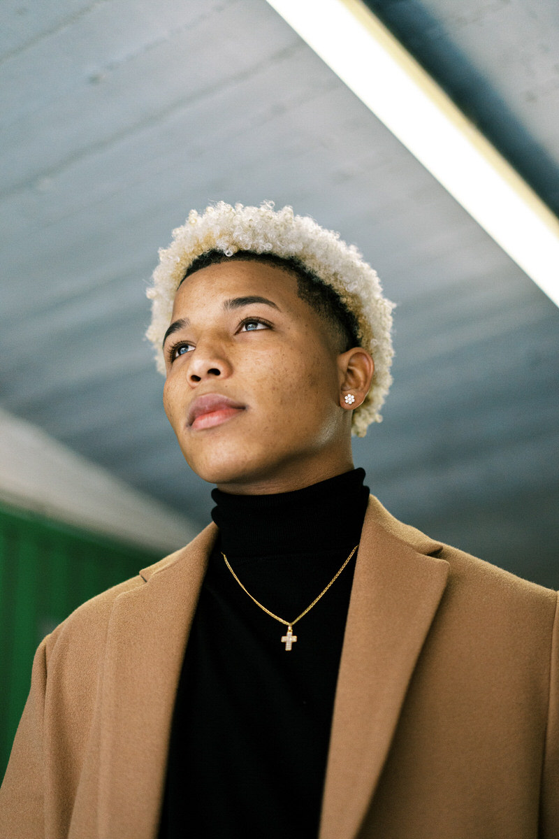 Funky black man in trendy clothes standing in underground corrid