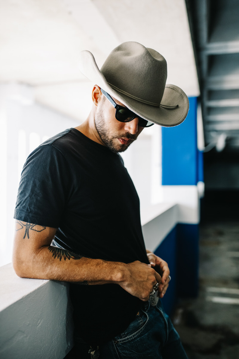 Handsome tattooed man in hat and sunglasses