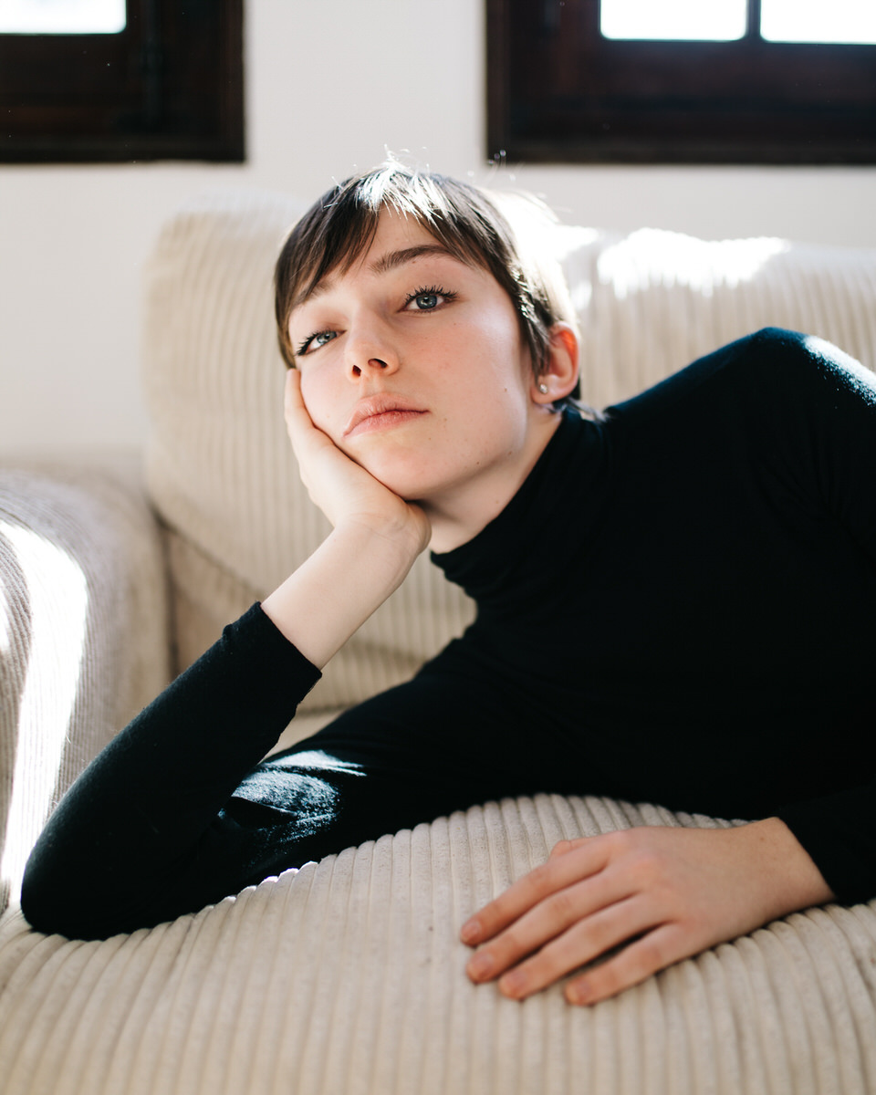 Charming woman in black lying on sofa