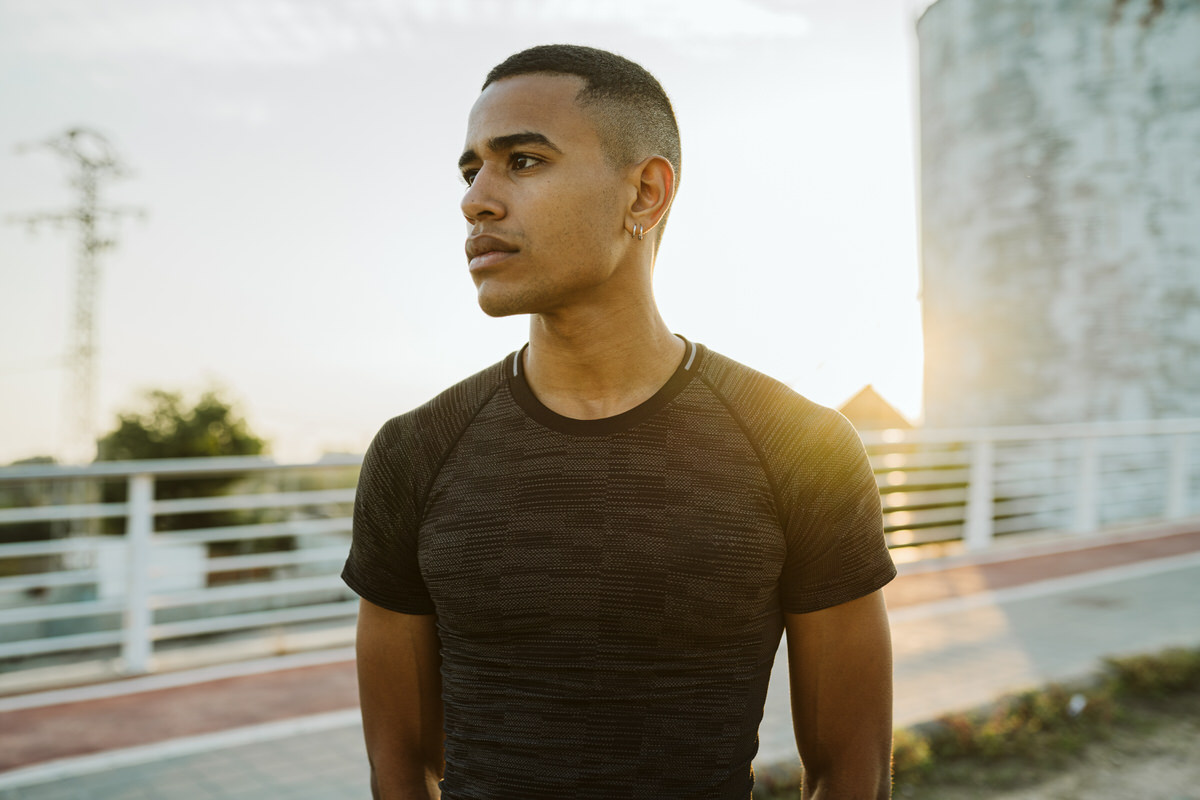 Serious black athlete near silo