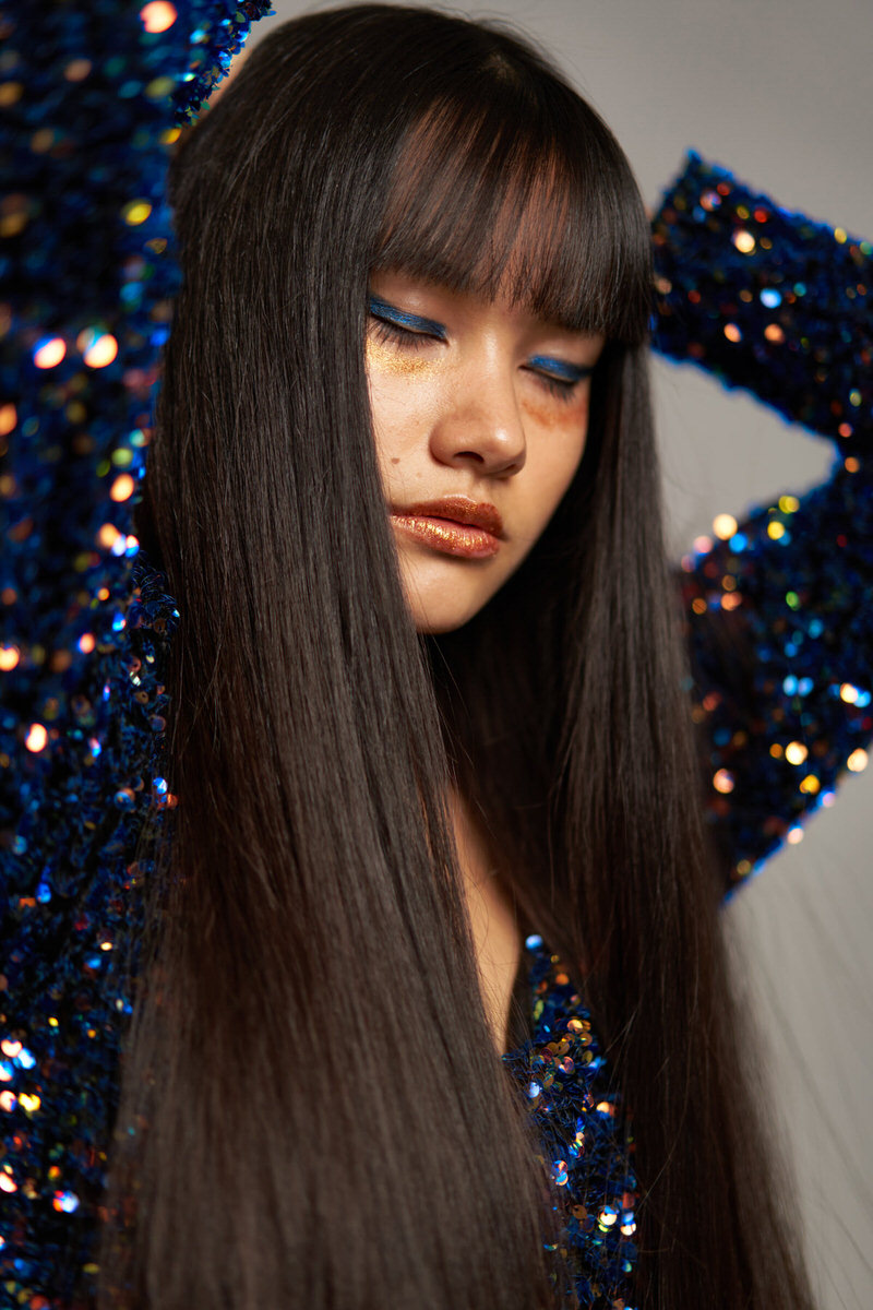 Serious long haired woman in shiny dress with closed eyes