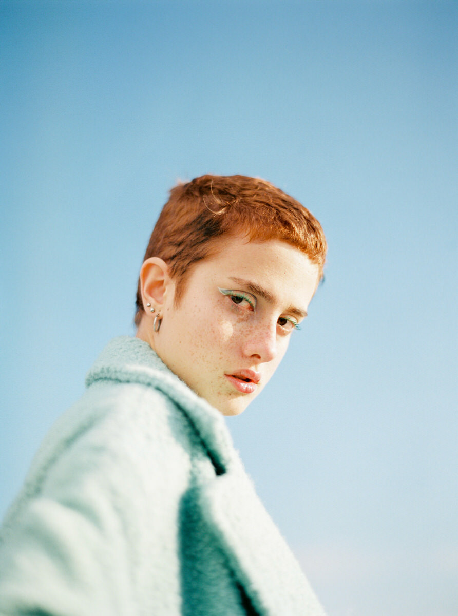 Concentrated young female model in coat in street