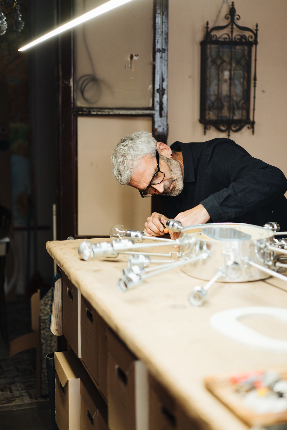 Senior craftsman making electric lamp