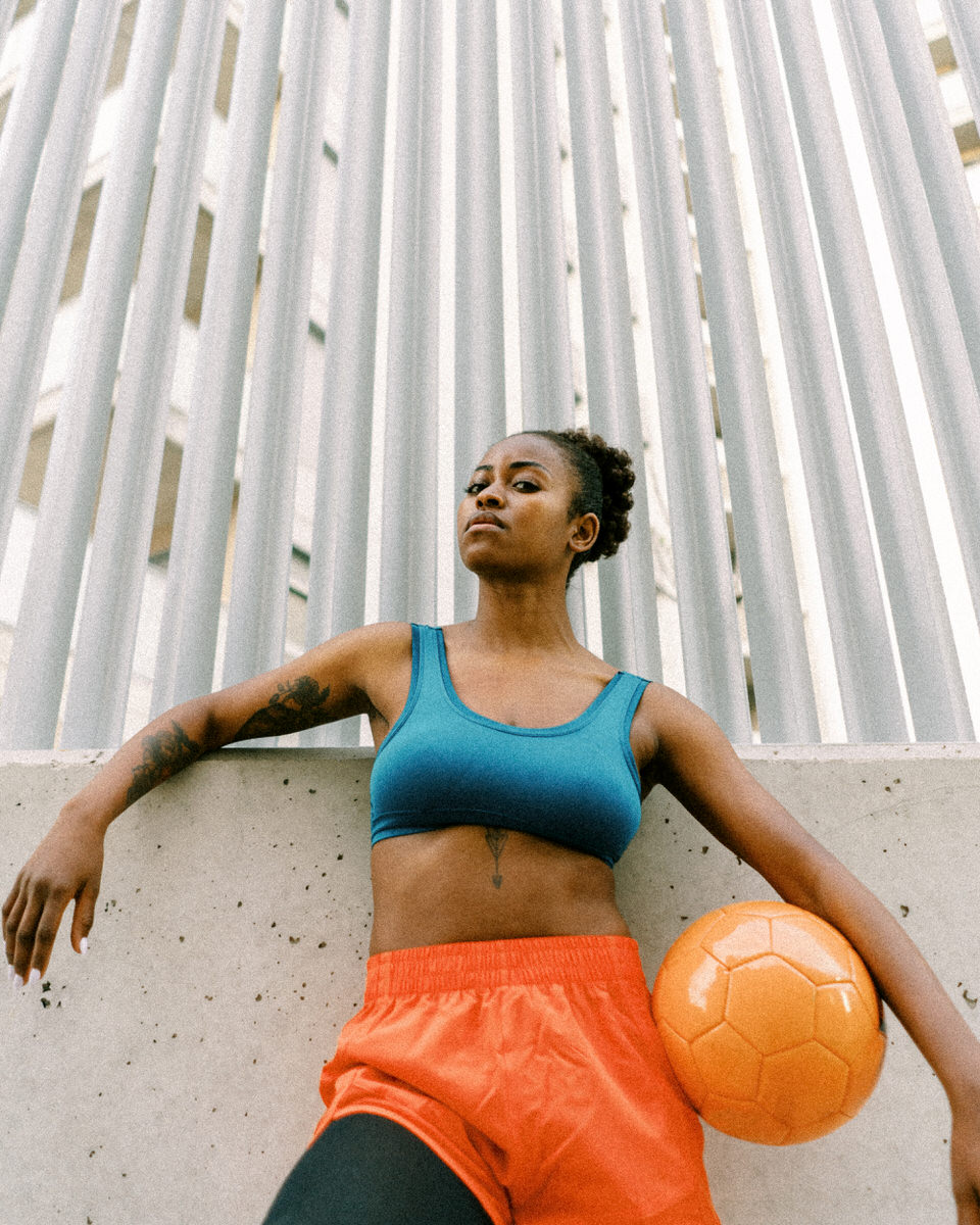 Athletic soccer player with ball in city