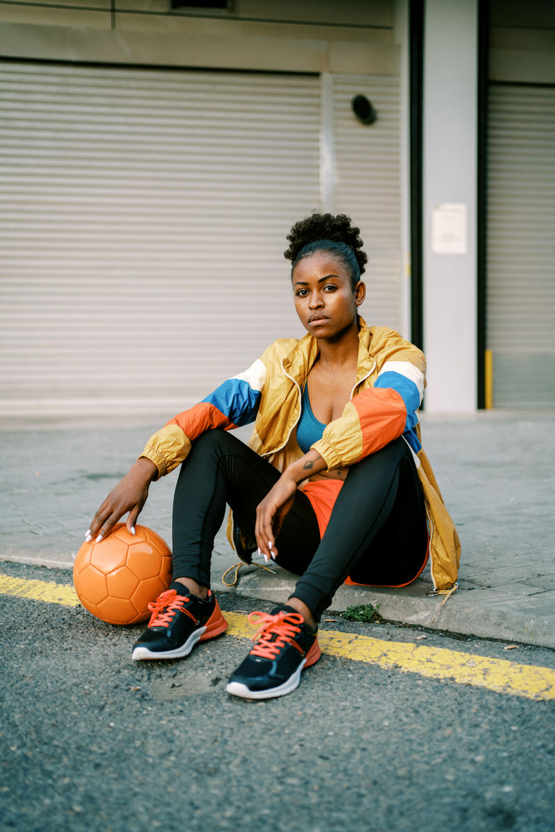 Female footballer with ball in city