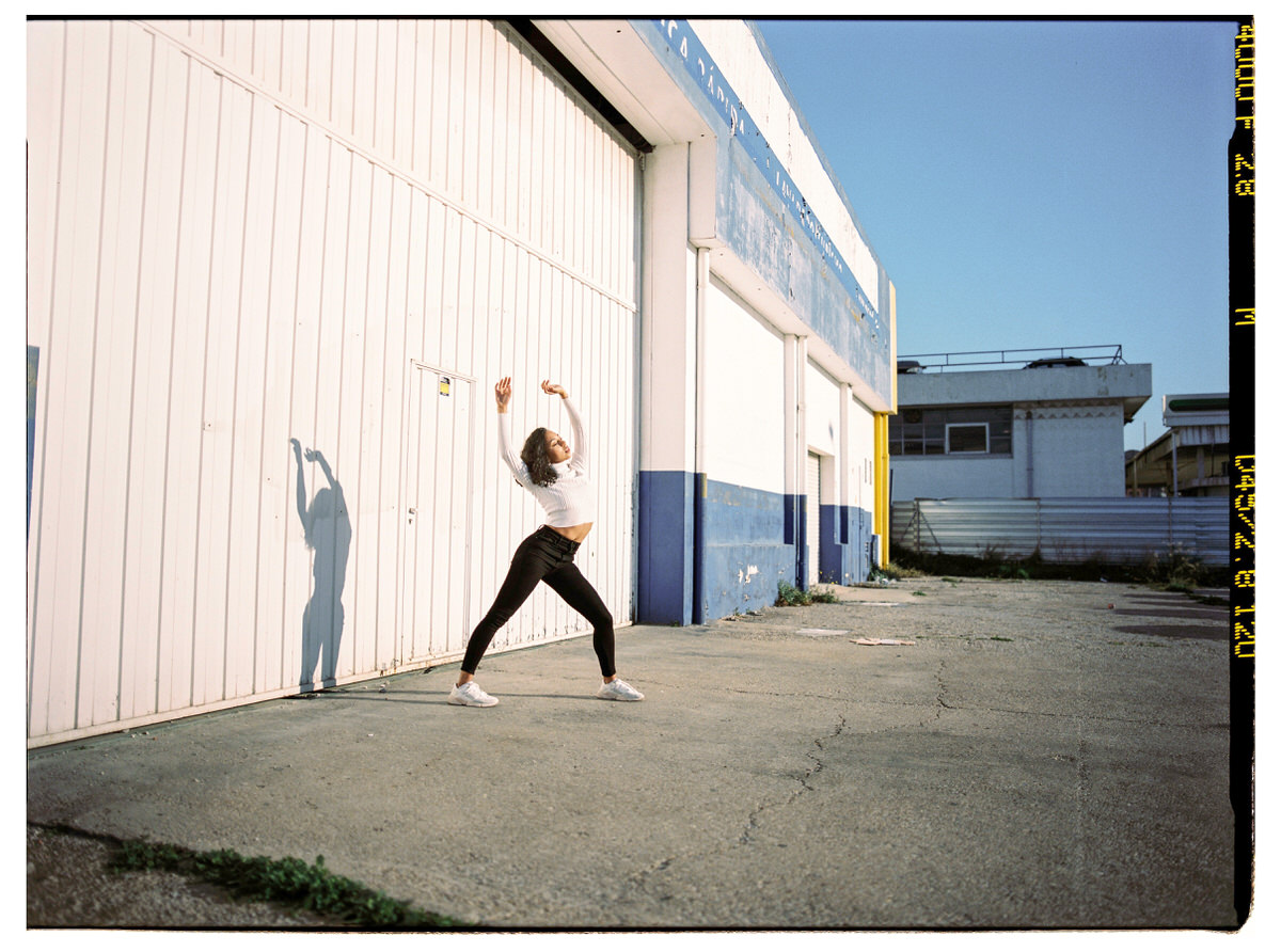Slim sportswoman warming up on street during training