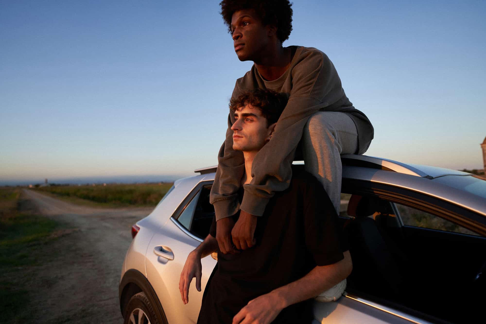 Men resting near car in evening