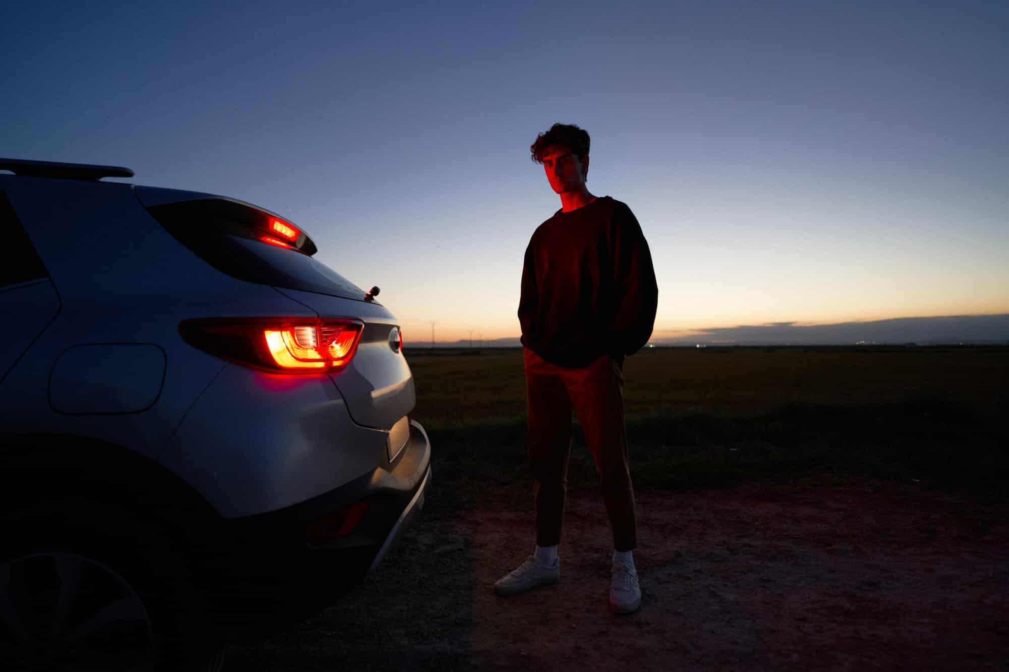 Man standing near car in evening